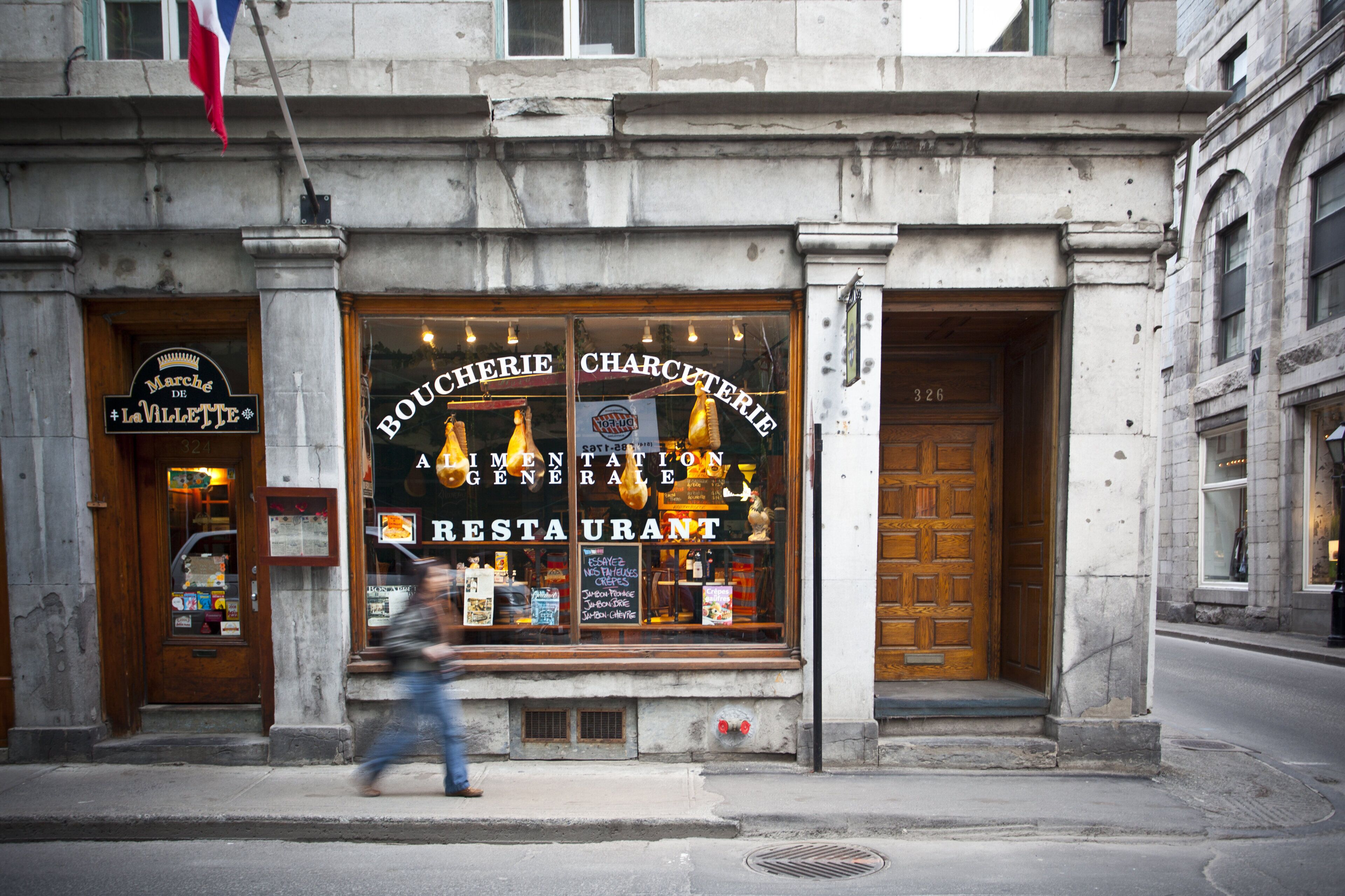 Un restaurant doté d’une grande vitrine et d’une porte en bois.