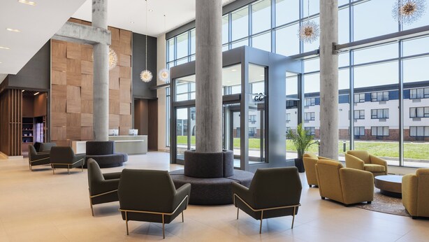A spacious lobby with modern furniture, large windows, and a view of the building's exterior. - Staybridge Suites Montréal Airport - St-Laurent by IHG (Montreal)