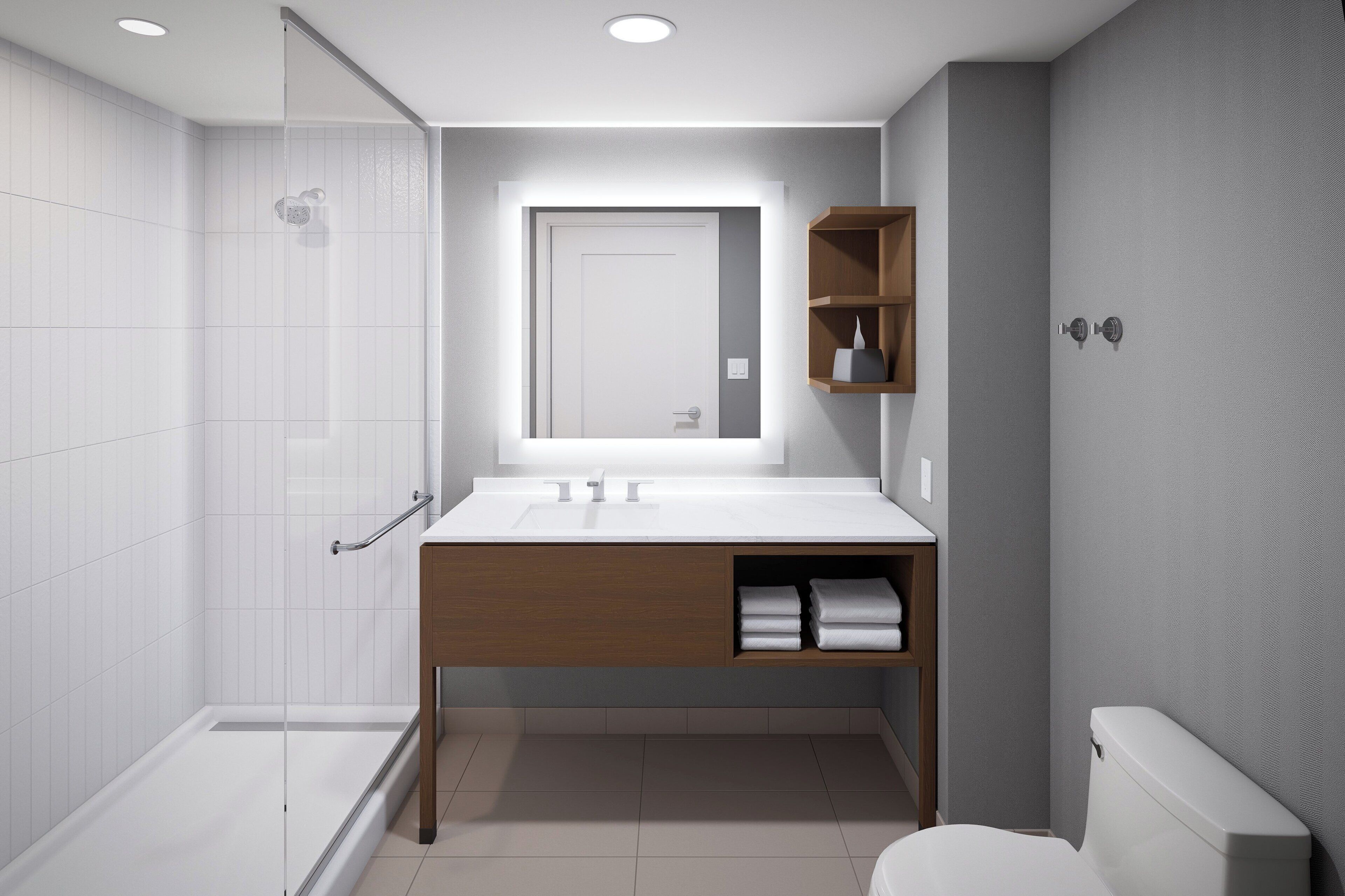 A modern bathroom with a glass shower enclosure, a wooden vanity with a mirror, and a toilet.