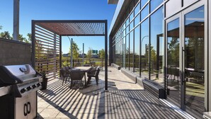 An outdoor patio with a grill, seating, and a pergola. - Staybridge Suites Montréal Airport - St-Laurent by IHG (Montreal)