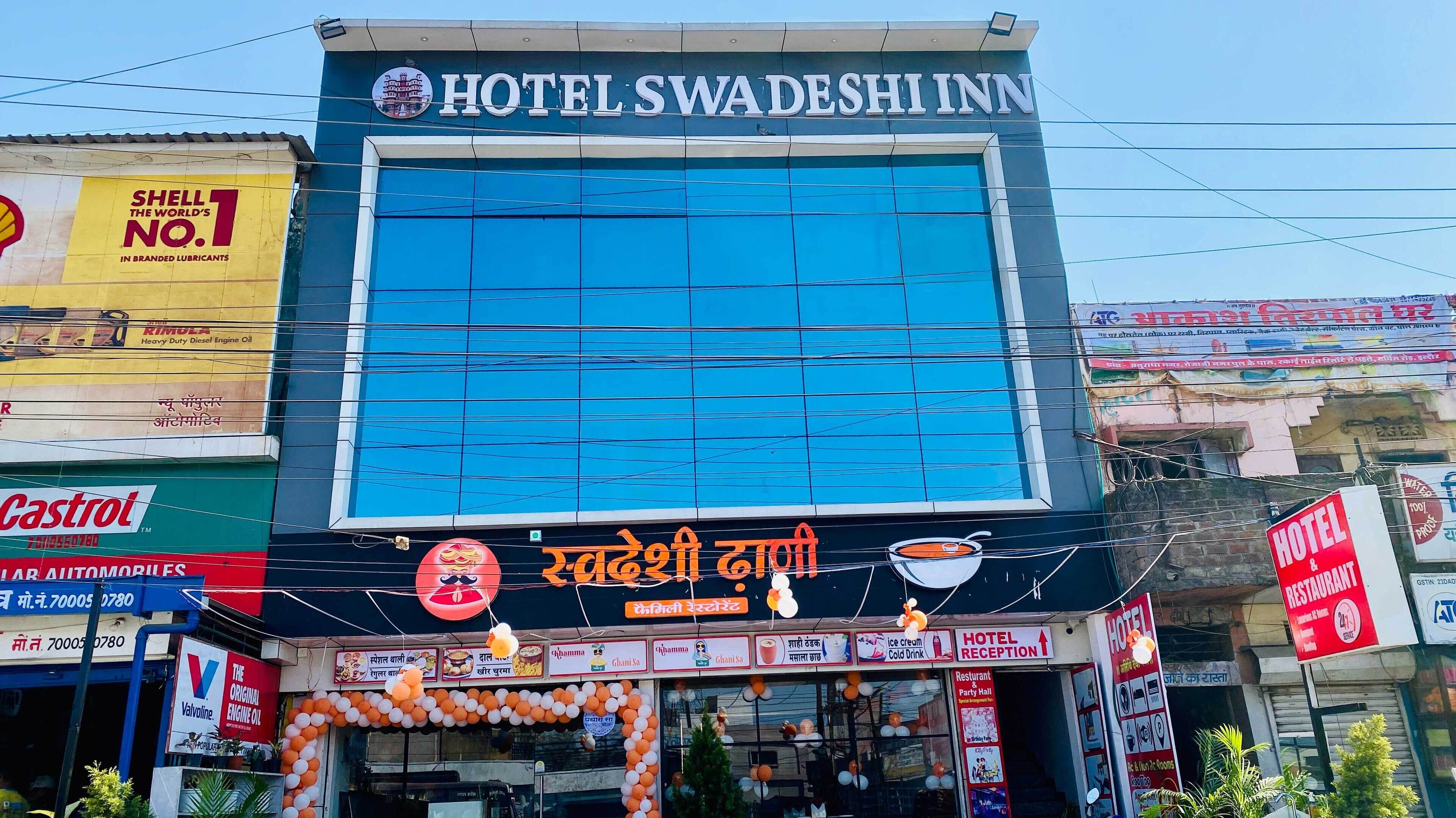 Un hotel con un ventanal azul grande y un letrero que dice "Hotel Swa Deshinn".