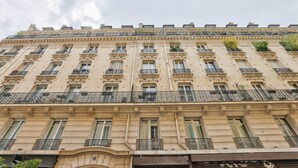 A multi-story building with a classic architectural style, featuring evenly spaced windows and ornate balconies. - A Peaceful Retreat in Le Marais (Paris)
