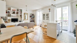A modern living space with a dining area, kitchen, and open-plan layout. - A Peaceful Retreat in Le Marais (Paris)