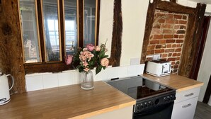 Een keuken met een houten aanrecht, een fornuis, een broodrooster en een vaas met bloemen.