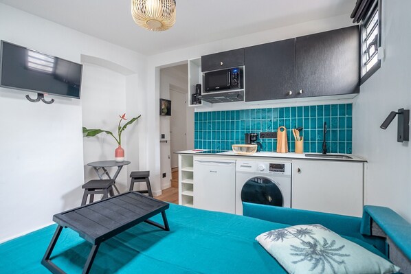 Um espaço compacto com cozinha compacta, área de jantar e cama.