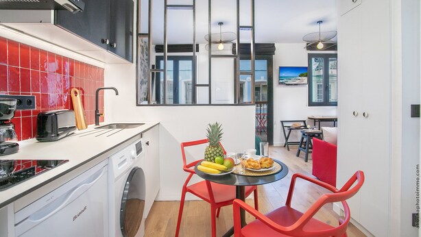A compact kitchen with a washing machine, a toaster, and a fruit plate on the counter. - Residence Nokoshima (Fort-de-France)