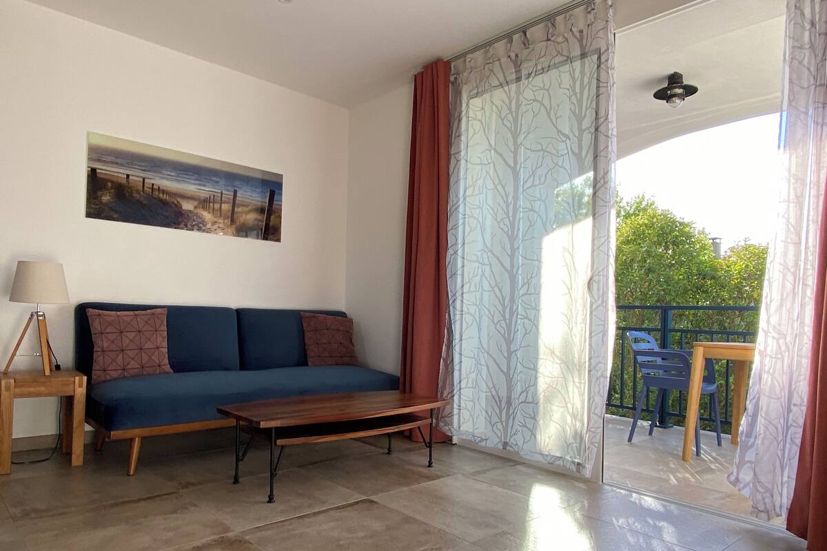 A living room with a sofa, a coffee table, a lamp, and a painting on the wall.
