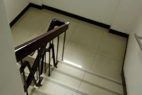 A staircase with a handrail and a tiled floor. - Hengbo Hotel (Shanghai)