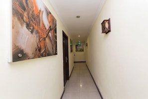 A hallway with a tiled floor, a door on the left, and a framed picture on the right. - Hengbo Hotel (Shanghai)