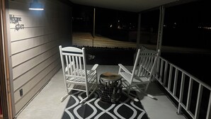 A covered porch with two white rocking chairs and a patterned rug. - 2-bedroom mobile home in enchanting Havasu Lake with WiFi, AC (Havasu Lake)