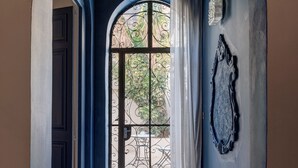 An arched doorway leading to a room with a tiled floor and a decorative mirror on the wall. - Modern Designer 2BR Apartment – Walk to Sea (Sliema)