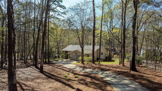 A cabin surrounded by tall trees with a clear sky.