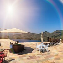 Una piscina techada, una piscina al aire libre, sombrillas