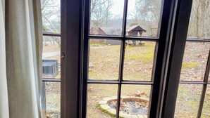 A view through a window with a stone wall and a wooden structure in the background. - Sam A Baker State Park (Patterson)