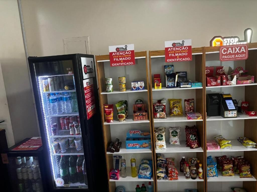 A vending machine and shelves stocked with snacks and beverages.