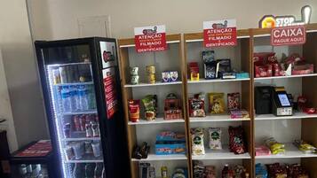 A vending machine and shelves stocked with snacks and beverages.