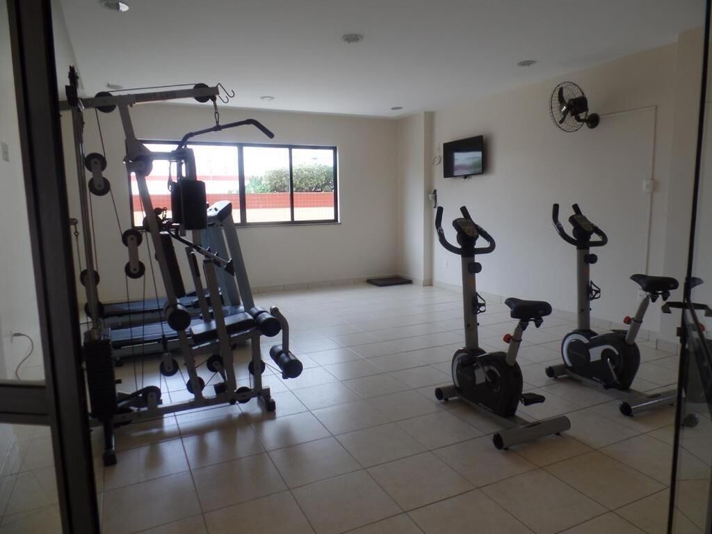 Un gimnasio con equipo de ejercicio, una cinta de correr y una máquina elíptica.