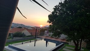 Una piscina con vista al atardecer y edificios circundantes.