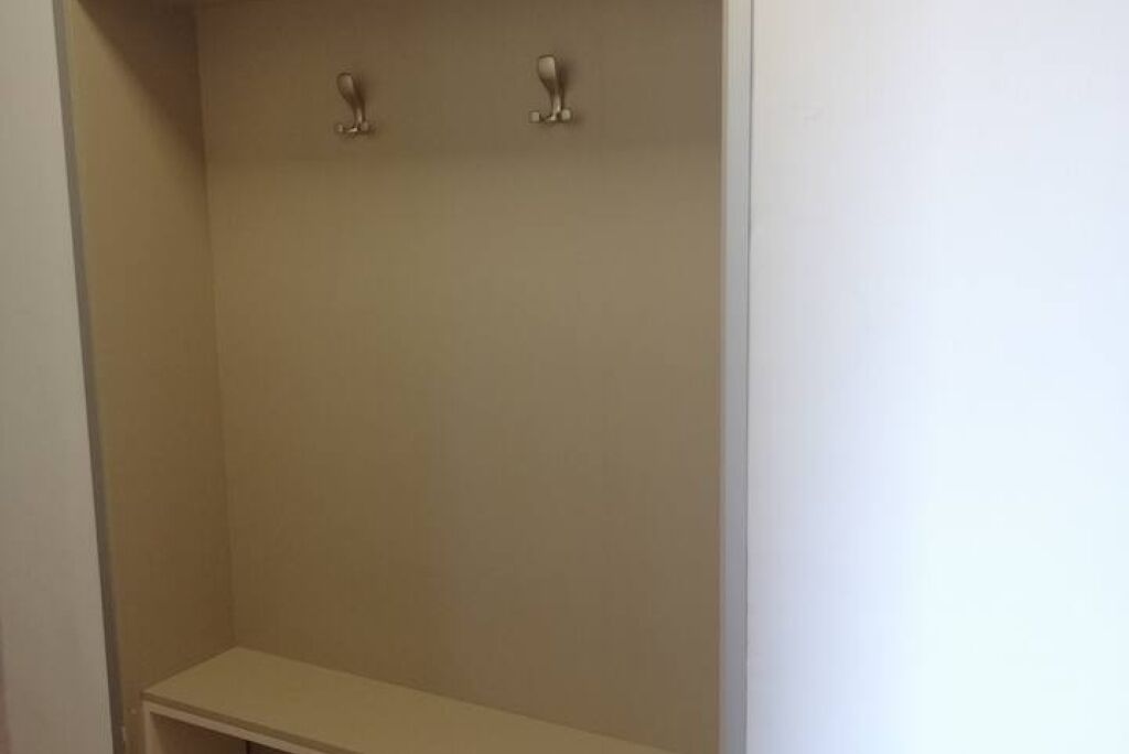 Een kast met twee metalen haken op het bovenste plank en een plank eronder.