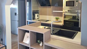 Una cocina moderna con microondas, horno y pileta integrados.