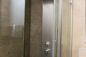 Regadera, secadora de cabello, toallas, papel de baño 