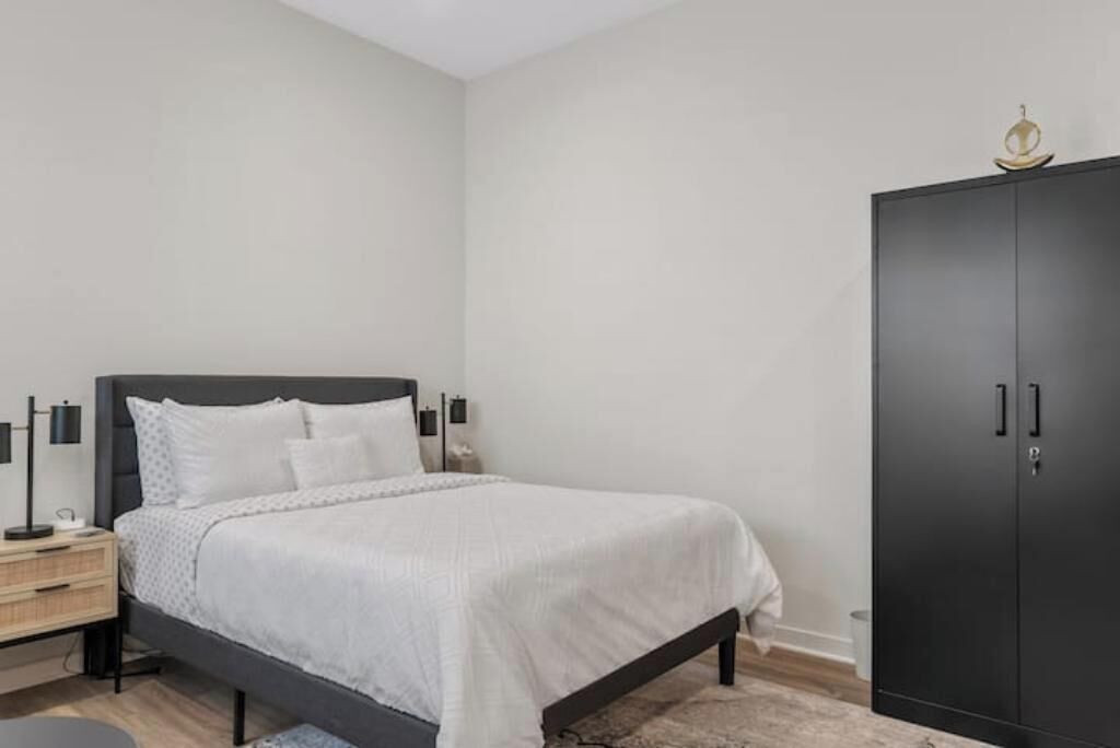 Une chambre à coucher comprenant un lit, des tables de chevet, une armoire et une commode.