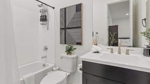 Un baño moderno con bañera, inodoro y lavamanos.
