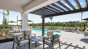 A covered outdoor area with a pool, lounge chairs, and umbrellas. - Resort-Style 2-Bedroom Townhome with Pool, WiFi, and AC in Sarasota (Sarasota)