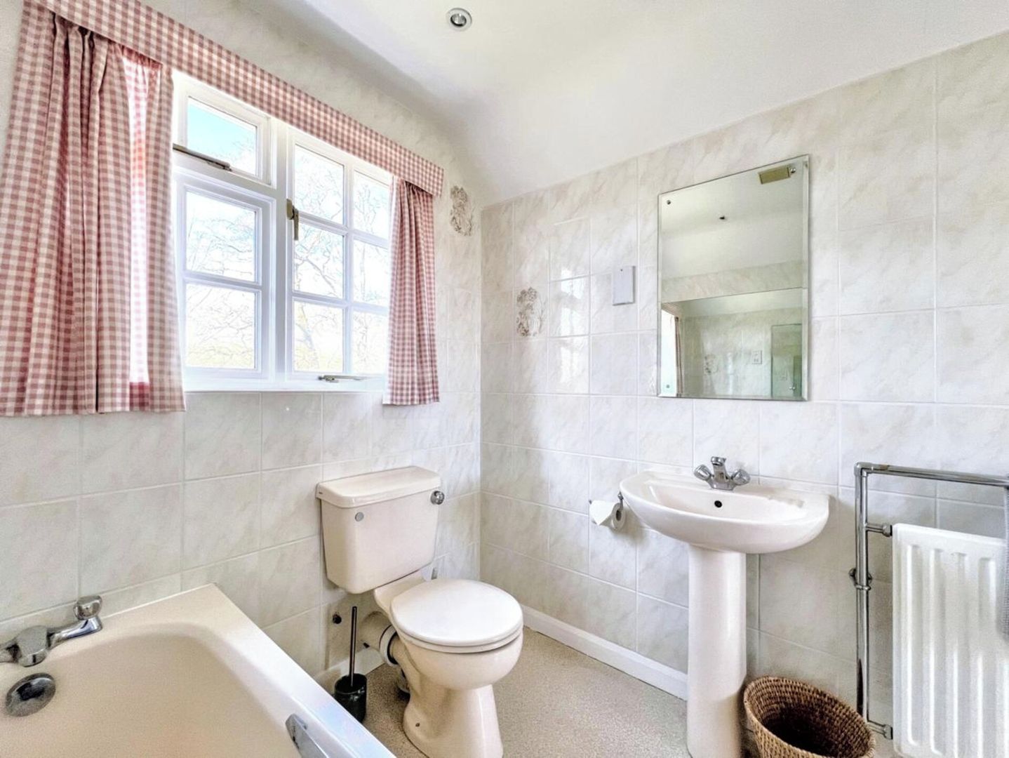 Un baño con bañera, inodoro, lavabo y espejo.