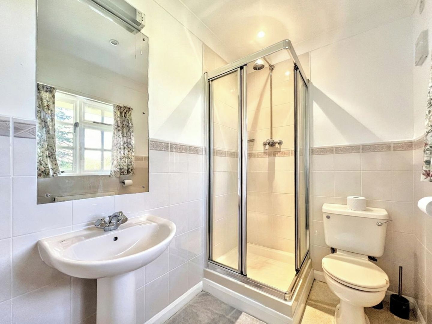 Une salle de bain avec une douche à parois de verre, un lavabo et des toilettes.