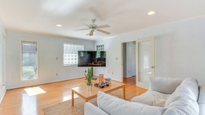 A spacious living room with a flat-screen TV, a ceiling fan, and a large window. - 1 Mi to Dwtn Shops & Dining: Spacious Family Home (Hartwell)