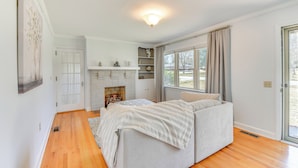 A bedroom with a bed, a fireplace, a window, and a door. - 1 Mi to Dwtn Shops & Dining: Spacious Family Home (Hartwell)