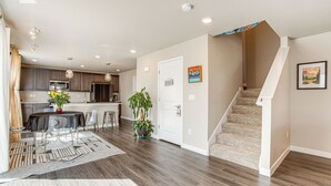 A modern kitchen with dark wood cabinets, a central island, and pendant lighting. - Beautiful Home w/ Bonus Room & Prime Location! (Brighton)