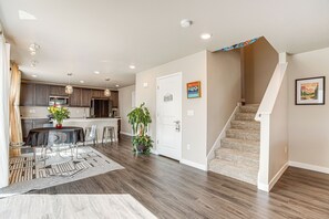 A modern kitchen with dark wood cabinets, a central island, and pendant lighting. - Beautiful Home w/ Bonus Room & Prime Location! (Brighton)