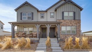 A two-story house with a front porch, stone accents, and a well-maintained lawn. - Beautiful Home w/ Bonus Room & Prime Location! (Brighton)