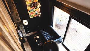 Een moderne keuken met een houten aanrecht, een zwarte kookplaat en een hangende lamp.