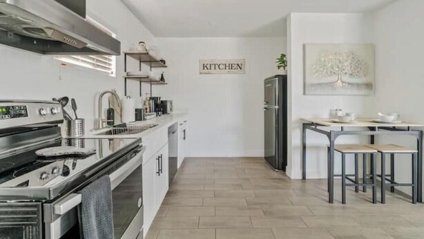 A modern kitchen with stainless steel appliances, a wooden floor, and a minimalist design. - Detached Private Guesthouse - Full Kitchen, 1BD + 1BA, Parking Spot - Sleeps 2 (Mesa)