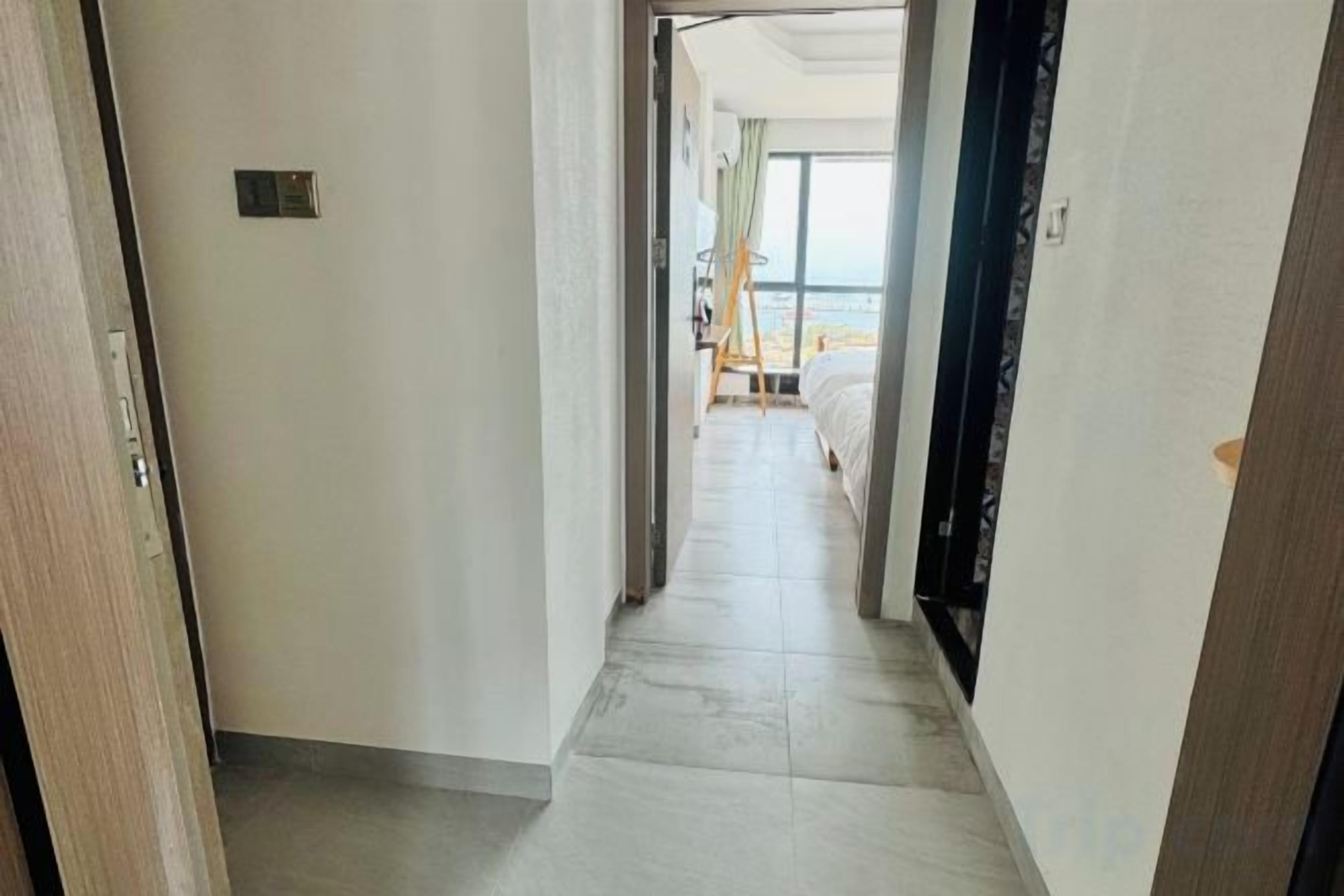 Un pasillo que conduce a una habitación con cama y vistas al mar.