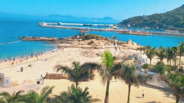 A beach with a pier, palm trees, and a mountainous backdrop. - Zhuhai Wailingding Island Wanghaige (Beach Swimming Area) (Zhuhai)