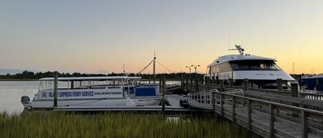 A ferry dock with a boat labeled "Island Express Ferry Service" and a docked yacht.