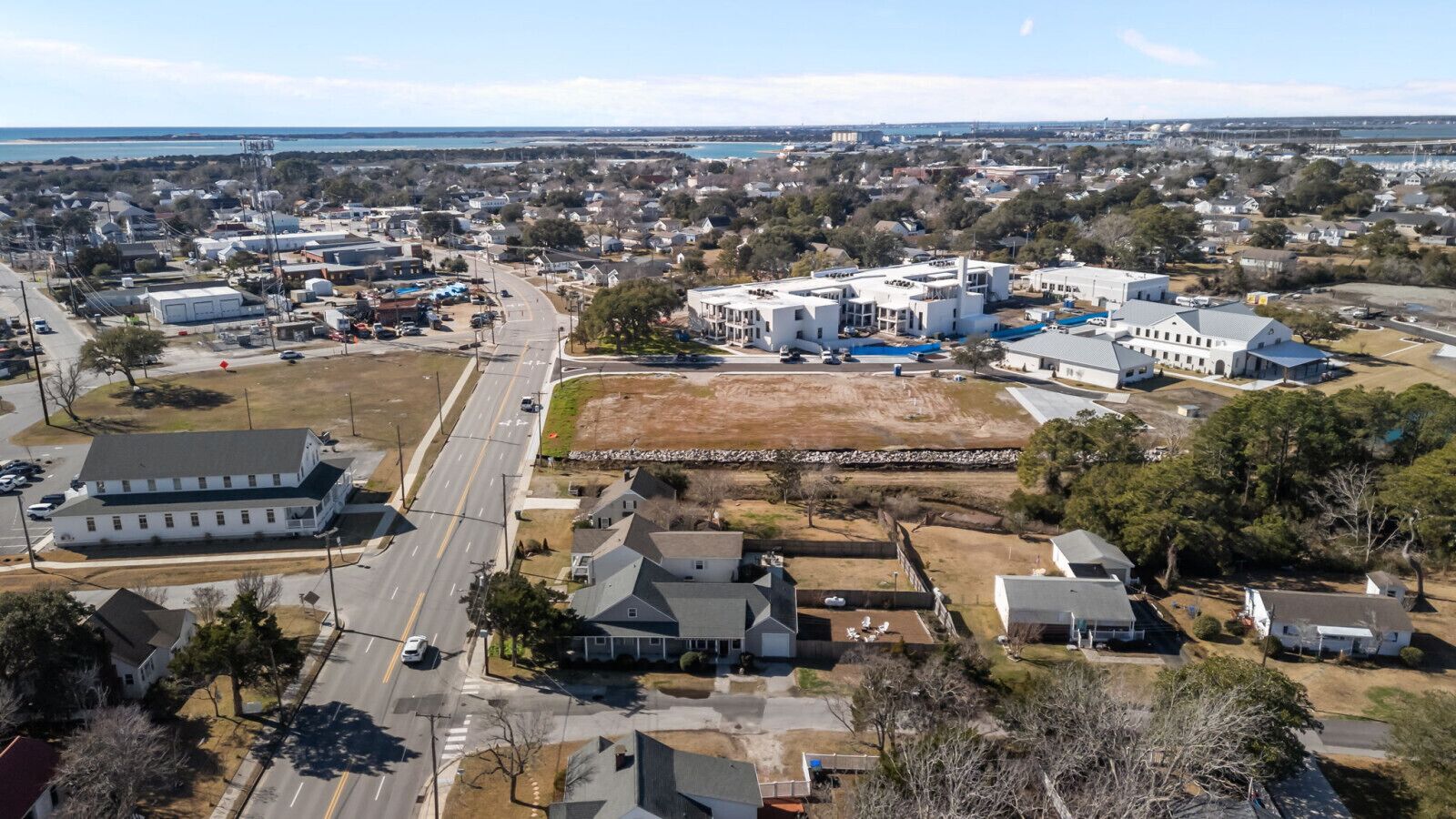 An aerial view of a residential area with houses, a large building, and a road.