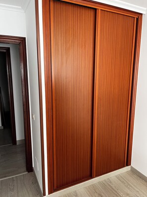 A classic wardrobe with a dark wood finish and white trim, complementing the room's warm atmosphere.