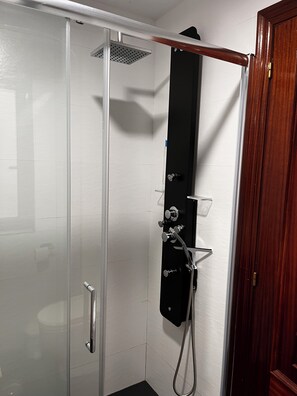 Shower area features a handheld and fixed showerhead, along with a handheld shower hose.