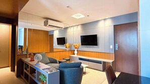Un salon moderne avec un canapé, une table basse et un téléviseur fixé au mur.
