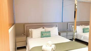 Una habitación de hotel con una cama grande, una mesita de noche y un armario.