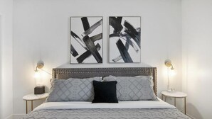 A modern bedroom with a large bed, two bedside tables, and abstract artwork on the wall. - Perfect for Large Group  5BD+3BA Free Parking (Mesa)