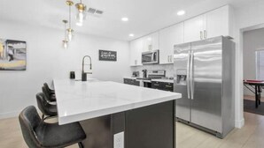 A modern kitchen with a central island, stainless steel appliances, and a pendant light fixture. - Perfect for Large Group  5BD+3BA Free Parking (Mesa)