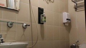 A bathroom with a sink, towel dispenser, and toilet paper holder. - Sanyi Happiness Bed and Breakfasts (Miaoli)
