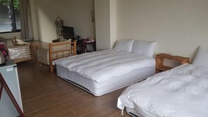 A hotel room with two beds, a desk with a computer, a chair, and a small refrigerator. - Sanyi Happiness Bed and Breakfasts (Miaoli)