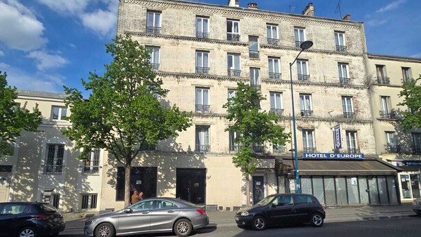 Un edificio de varios pisos con un letrero que dice "HOTEL D'EUROPE" en la planta baja.